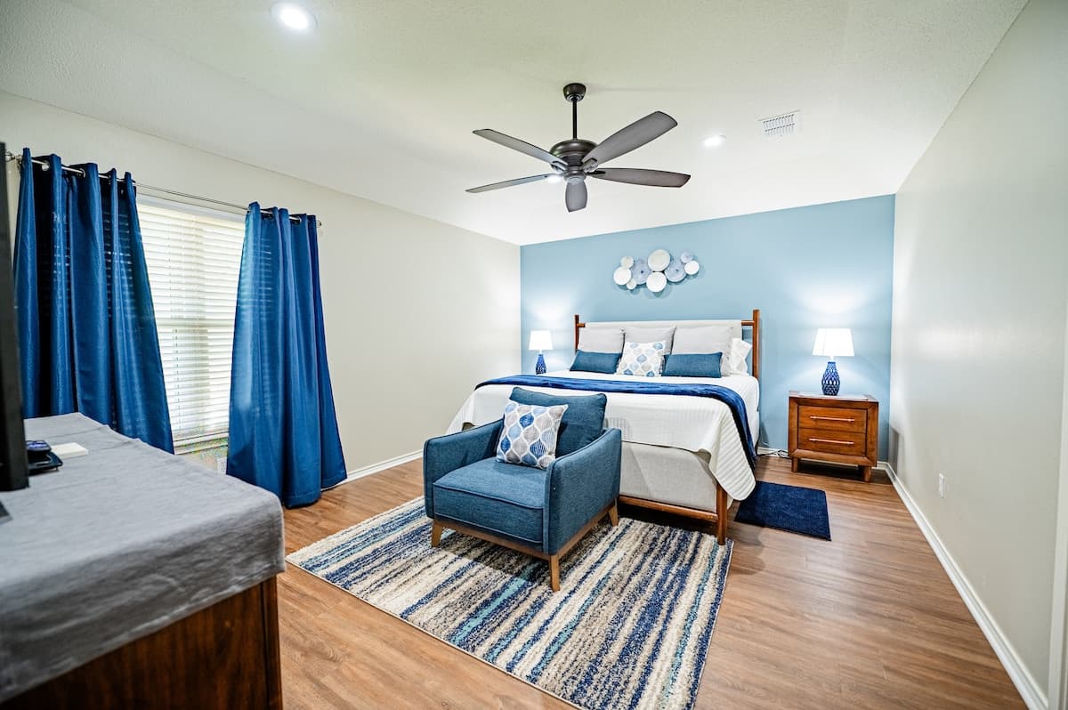 Primary bedroom with a king-size bed and a seating area.