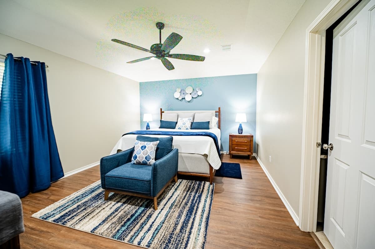 Primary bedroom with a king-size bed and a seating area.